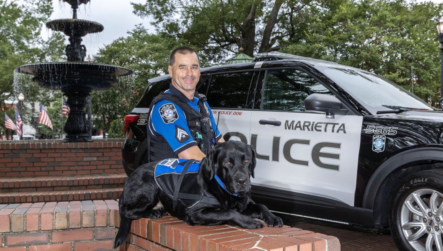  Police officer and therapy dog in front of police vehicle